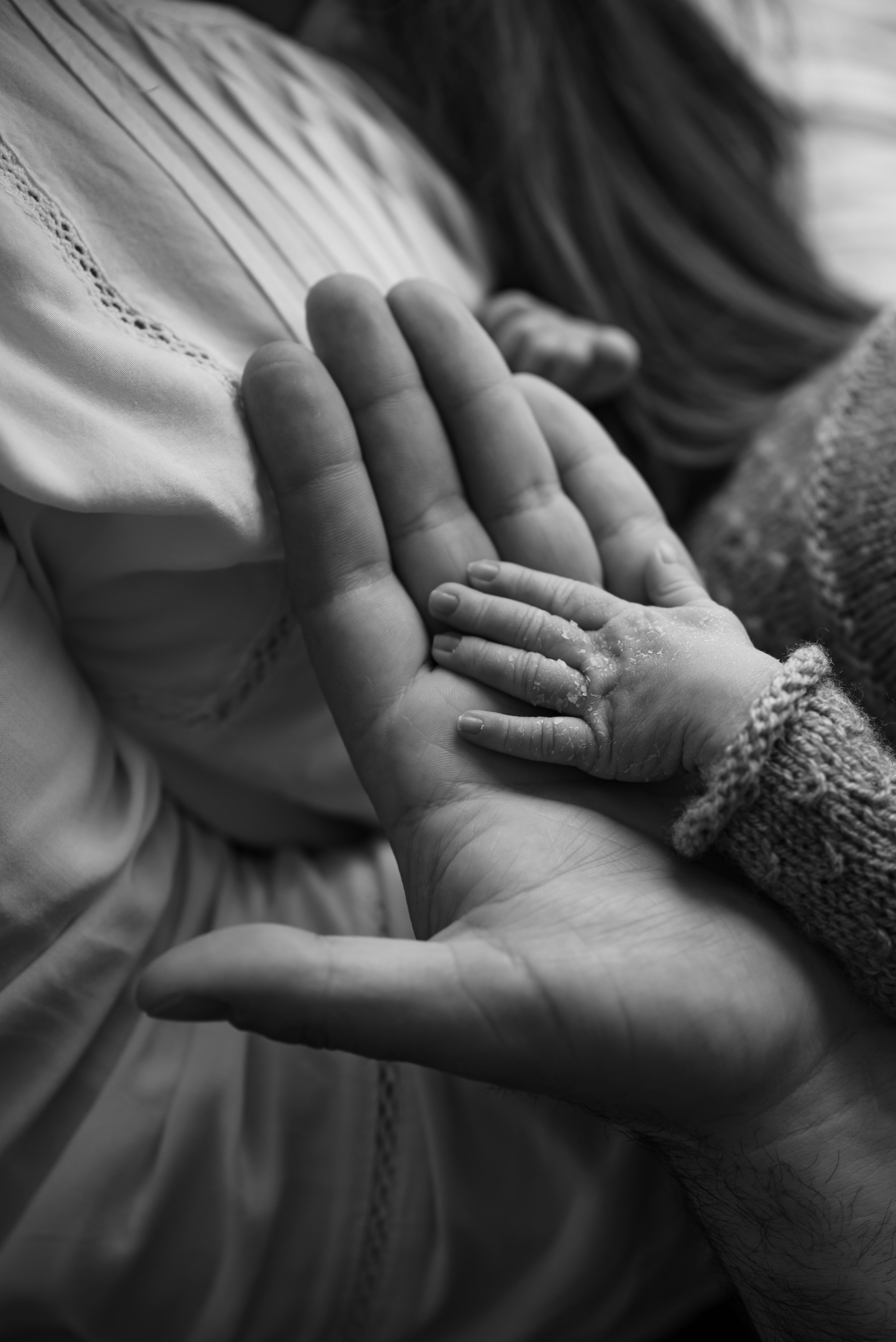 A child’s hand resting in an adult’s open palms